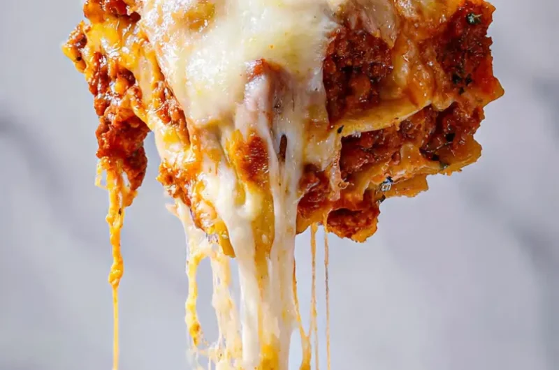 Extreme close up of a cheese pull from a meat-heavy carnivore lasagna.