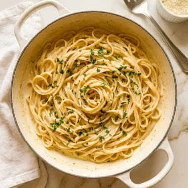 One Pot Creamy Garlic Pasta in a white ceramic bowl topped with Parmesan and parsley on white marble