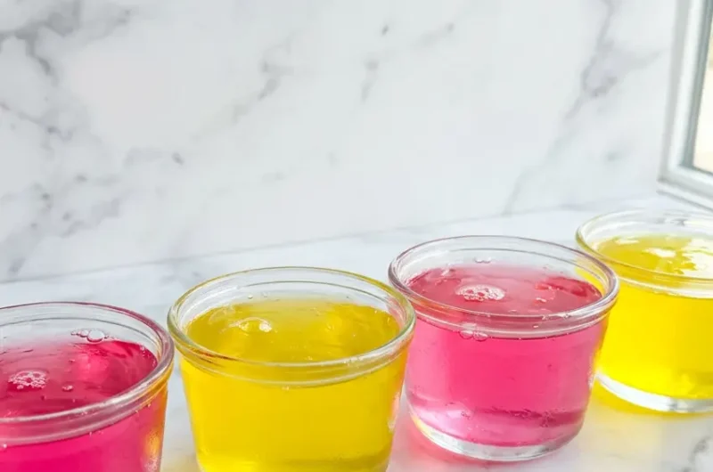 Pinterest pin image for bariatric gelatin recipe showing pink and yellow gelatin cups on white marble