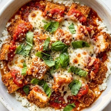 Extreme close up of a bubbling cottage cheese chicken parm bowl with stretchy mozzarella cheese.