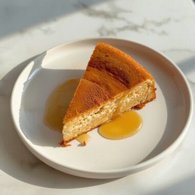 Golden honey cinnamon dessert slice on white plate with warm cinnamon garnish