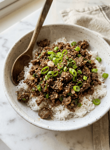Korean ground beef bowl with glossy savory sauce over jasmine rice topped with sesame seeds
