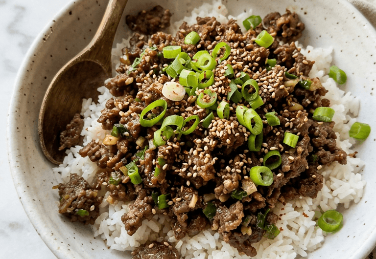 Korean ground beef bowl with glossy savory sauce over jasmine rice topped with sesame seeds