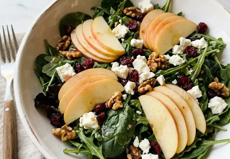 honeycrisp apple feta salad in a white ceramic bowl with toasted walnuts and cranberries