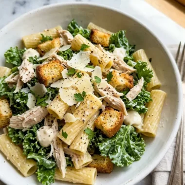 high-protein kale chicken caesar pasta salad in white bowl with croutons and Parmesan
