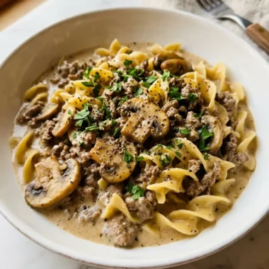 easy ground beef stroganoff in a white ceramic bowl with fresh parsley