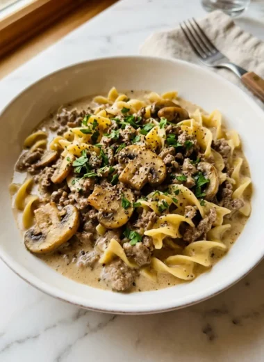 easy ground beef stroganoff in a white ceramic bowl with fresh parsley