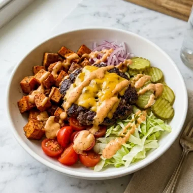 Smash Burger Bowl with crispy beef, sweet potatoes, lettuce, tomatoes, pickles, and cheddar