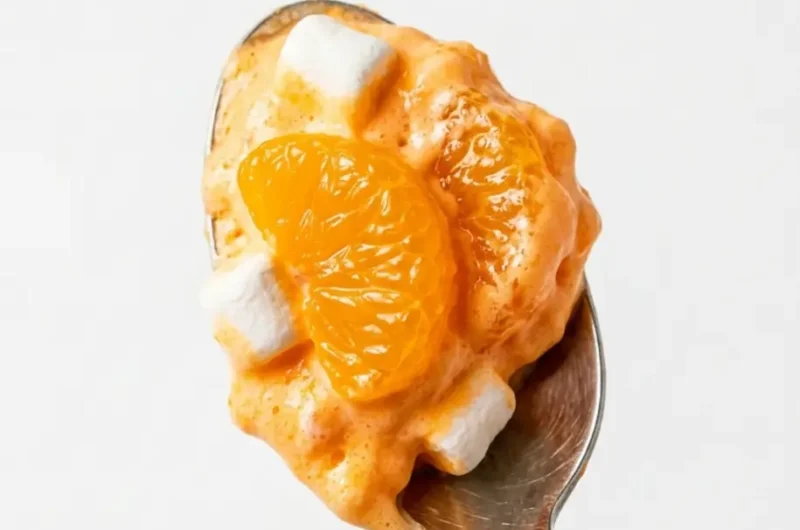Pinterest pin image for Mandarin Orange Jello Salad showing a creamy orange fluff spoonful