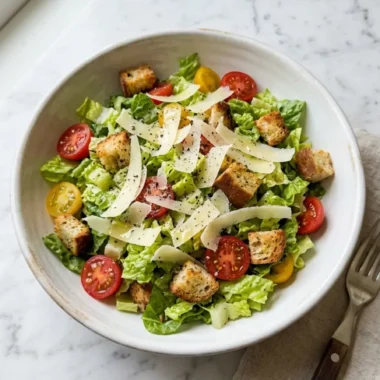 Parmesan Chopped Salad in a white ceramic bowl with cherry tomatoes and shaved Parmesan