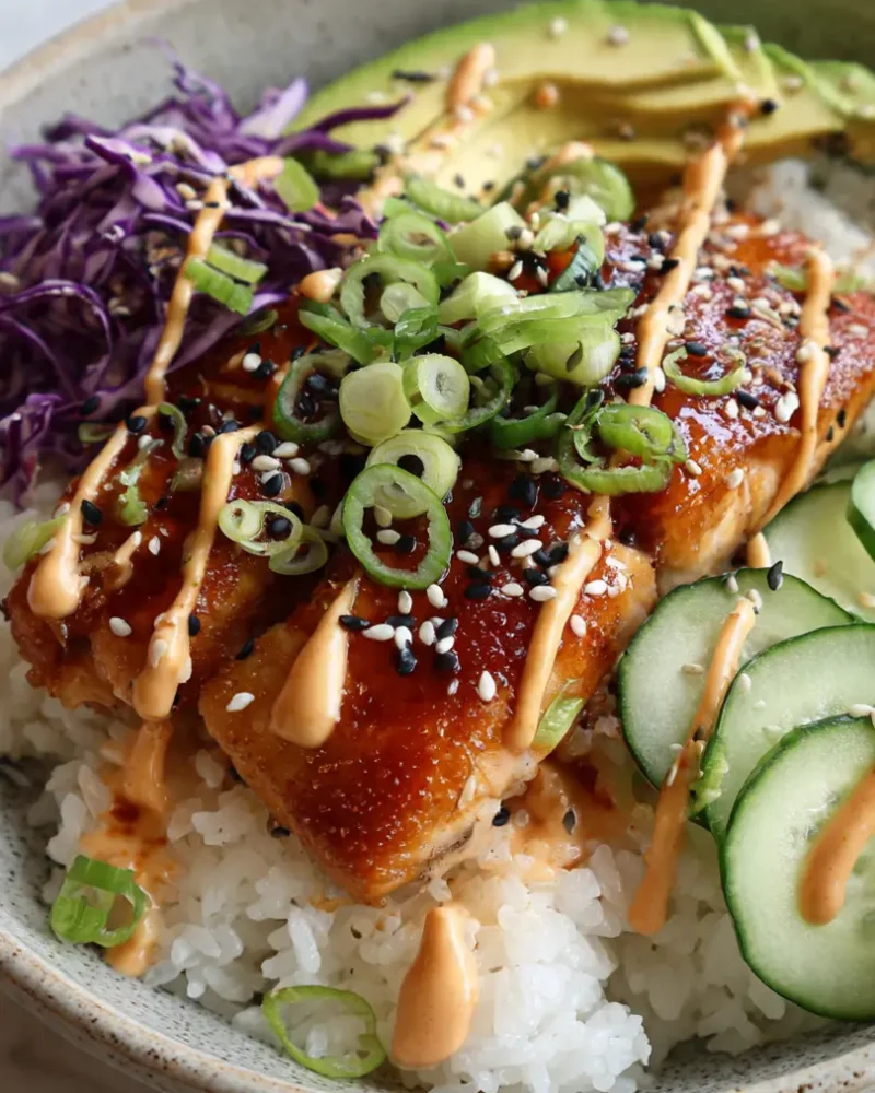 Overhead view of a crispy salmon and rice bowl served with a glass of water on a marble counter